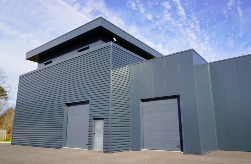 A large building with two doors and a sky background